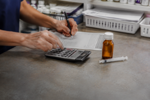 A pharmacy technician working through a dosage calculation — hero for 'Pharmacy Math Made Simple.